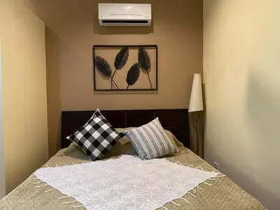a bedroom with a bed with two pillows on it at Tagaytay Foothills Cherimoya Farm - Pugad 2 in Calamba
