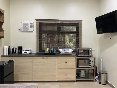 a kitchen with a counter top and a microwave at Tagaytay Foothills Cherimoya Farm - Pugad 2 in Calamba
