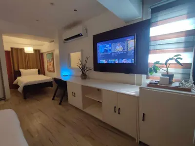 a living room with a flat screen tv on a wall at L1 Twin Bed Staycation in BGC in Manila