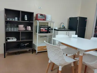 a kitchen with a table and chairs and a refrigerator at unit 129 Studio Type Avida Cityflex BGC in Manila