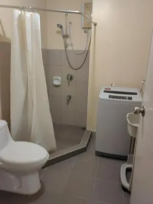a bathroom with a shower and a toilet and a sink at unit 129 Studio Type Avida Cityflex BGC in Manila