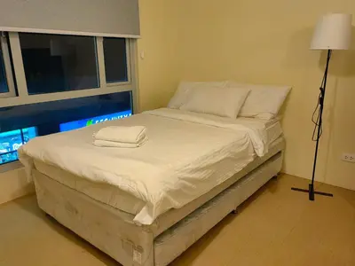 a bed with two towels on it in a room at unit 129 Studio Type Avida Cityflex BGC in Manila
