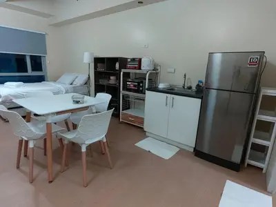a kitchen with a table and a refrigerator at unit 129 Studio Type Avida Cityflex BGC in Manila