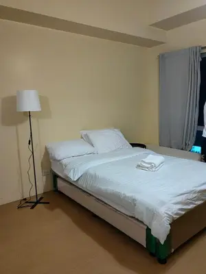 a bedroom with a bed with a lamp on it at unit 130 Studio Type Avida Cityflex BGC in Manila