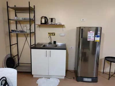 a kitchen with a sink and a refrigerator at unit 130 Studio Type Avida Cityflex BGC in Manila