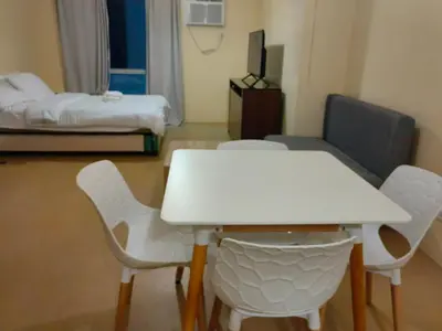 a room with a white table and chairs and a bed at unit 130 Studio Type Avida Cityflex BGC in Manila