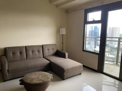 a living room with a couch and a large window at The Radiance Manila Bay 1BR in Manila