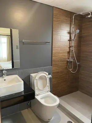 a bathroom with a toilet and a sink and a shower at The Radiance Manila Bay 1BR in Manila