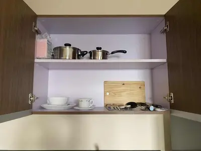 a kitchen with two pots and pans on a shelf at The Radiance Manila Bay 1BR in Manila