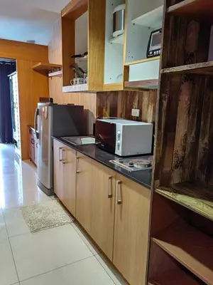 a kitchen with a microwave and a refrigerator at Apartment Shell Residences near MOA in Manila