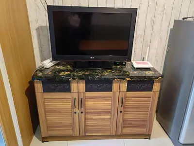 a flat screen tv on top of a wooden entertainment center at Apartment Shell Residences near MOA in Manila
