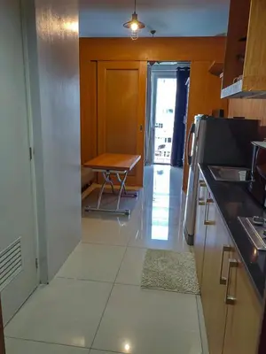 a kitchen with a table and a counter top at Apartment Shell Residences near MOA in Manila