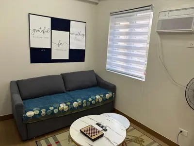 a living room with a couch and a table at G-VibeZzz Staycation in Trece Martires
