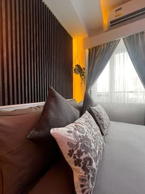 a bedroom with a bed with pillows and a window at Zhafira Retreat in Manila