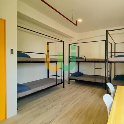 a room with three bunk beds and a table at Woke Coliving Kanlaon in Manila