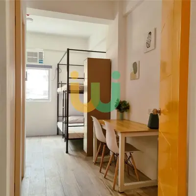a room with a table and chairs and a bedroom at Woke Coliving Kanlaon in Manila