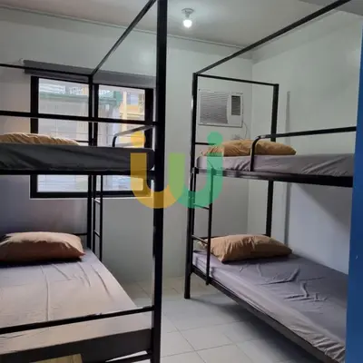 two bunk beds in a room with a window at Woke Coliving Kanlaon in Manila