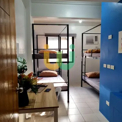 a room with two bunk beds and a table at Woke Coliving Kanlaon in Manila