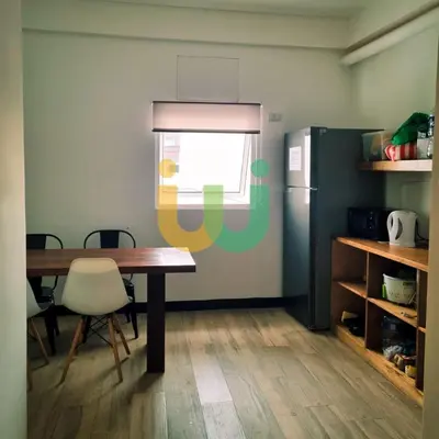 a dining room with a table and a refrigerator at Woke Coliving Kanlaon in Manila
