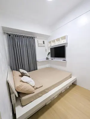 a small bedroom with a bed and a flat screen tv at Friends Zone - 2BR condo unit in Mandaluyong in Manila