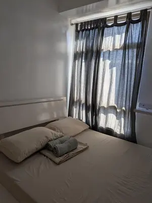 a bed in a bedroom with a window at Friends Zone - 2BR condo unit in Mandaluyong in Manila