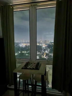 a table and two chairs in front of a large window at Doc Odette Studio Staycation in Manila