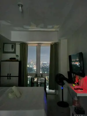 a hotel room with a bed and a large window at Doc Odette Studio Staycation in Manila