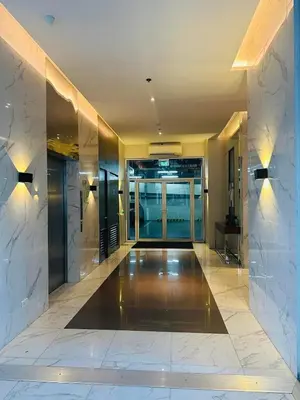 a lobby with a hallway with glass doors and marble walls at Doc Odette Studio Staycation in Manila
