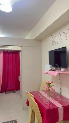 a dining room with a table with a pink table cloth at 10th Floor Staycation in Manila