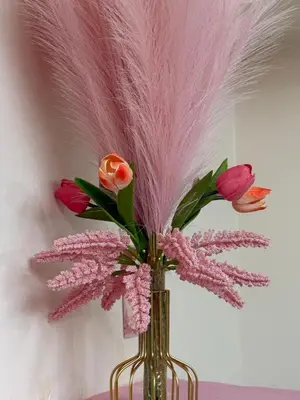 a vase filled with pink flowers and feathers at 10th Floor Staycation in Manila