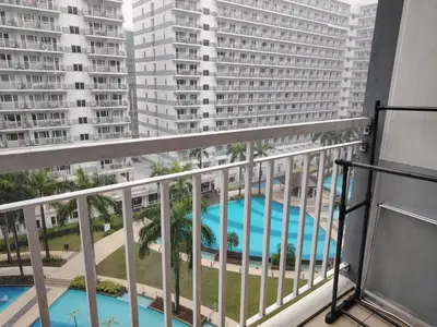 a balcony with a view of a pool and buildings at AteAbyPlace830 in Manila
