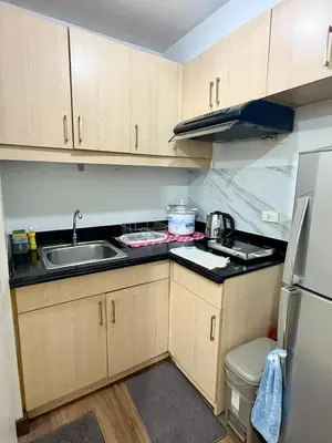 a small kitchen with a sink and a refrigerator at 1BR LaVerti Cloud Nine Suite Family affordable staycation in Manila