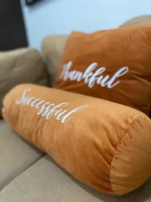 two brown pillows on a couch with the word ketchup at Sunrise Haven in Makati AIR Residences in Manila