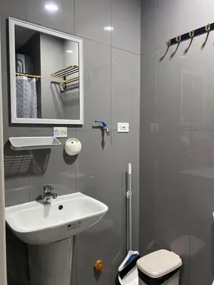 a bathroom with a sink and a toilet and a mirror at Sunrise Haven in Makati AIR Residences in Manila