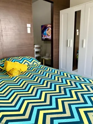 a yellow stuffed animal laying on top of a bed at Sunrise Haven in Makati AIR Residences in Manila
