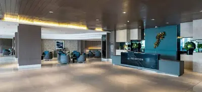 a lobby of a hotel with a reception desk and chairs at Shore Residences Moa View in Manila