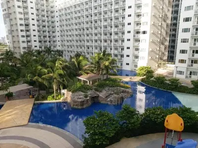 an aerial view of a large building with blue water at Shore Residences Moa View in Manila