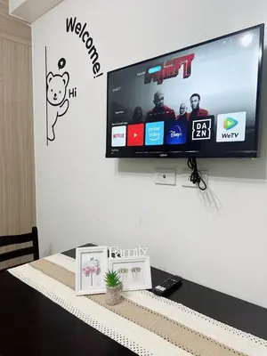 a flat screen tv on a wall with a table at Shore Residences Moa View in Manila