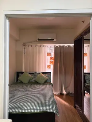 a bedroom with a bed and a window with curtains at Casita avec Amour at Lumiere Residences in Manila