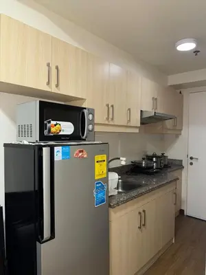 a kitchen with a microwave on top of a refrigerator at Casita avec Amour at Lumiere Residences in Manila