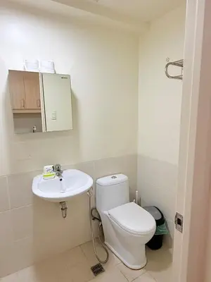 a bathroom with a toilet and a sink at Casita avec Amour at Lumiere Residences in Manila