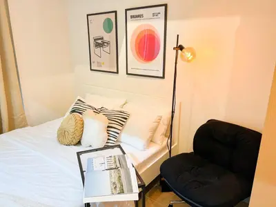 a bedroom with a bed with a lamp and a chair at Prime BGC 1BR Near Grand Hyatt & Malls #upt215e in Manila