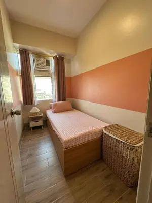 a small bedroom with a bed and a window at Family Comfort Zone Staycation at Greenhills in Manila