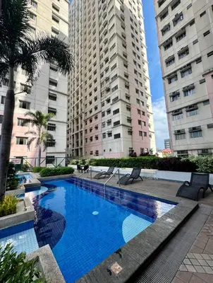 a swimming pool in the middle of two tall buildings at Family Comfort Zone Staycation at Greenhills in Manila