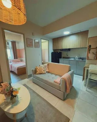 a living room with a couch and a kitchen at Family Comfort Zone Staycation at Greenhills in Manila
