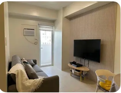 a living room with a couch and a flat screen tv at 1Bedroom, living room w balcony ADHI staycation in Biñan