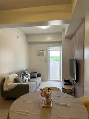a living room with a couch and a tv at 1Bedroom, living room w balcony ADHI staycation in Biñan