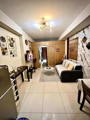 a living room with a couch and a table at Staycation Near Mall of Asia in Manila