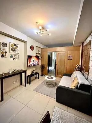 a living room with a couch and a tv at Staycation Near Mall of Asia in Manila