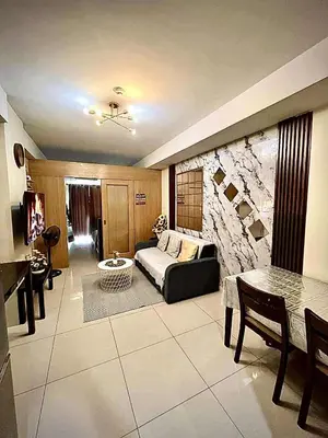 a living room with a bed and a table at Staycation Near Mall of Asia in Manila